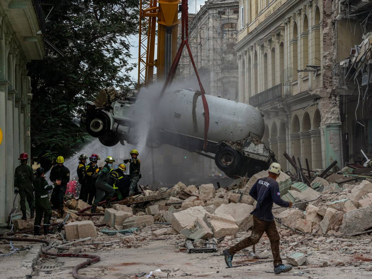 06.05.2022, Kuba, Havanna: Feuerwehrleute besprühen einen Tankwagen mit Wasser, um ihn zu kühlen, während sie ihn vom Ort einer tödlichen Explosion entfernen, die das Fünf-Sterne-Hotel Saratoga in Havanna, Kuba, zerstört hat.