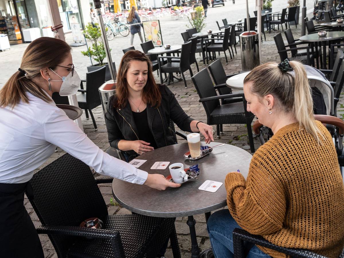 Sarah Borgholte (M) und Angelique Paul-Brackelmann (r) bekommen vor der Brasserie „Lamäng“ ihren Kaffee serviert.