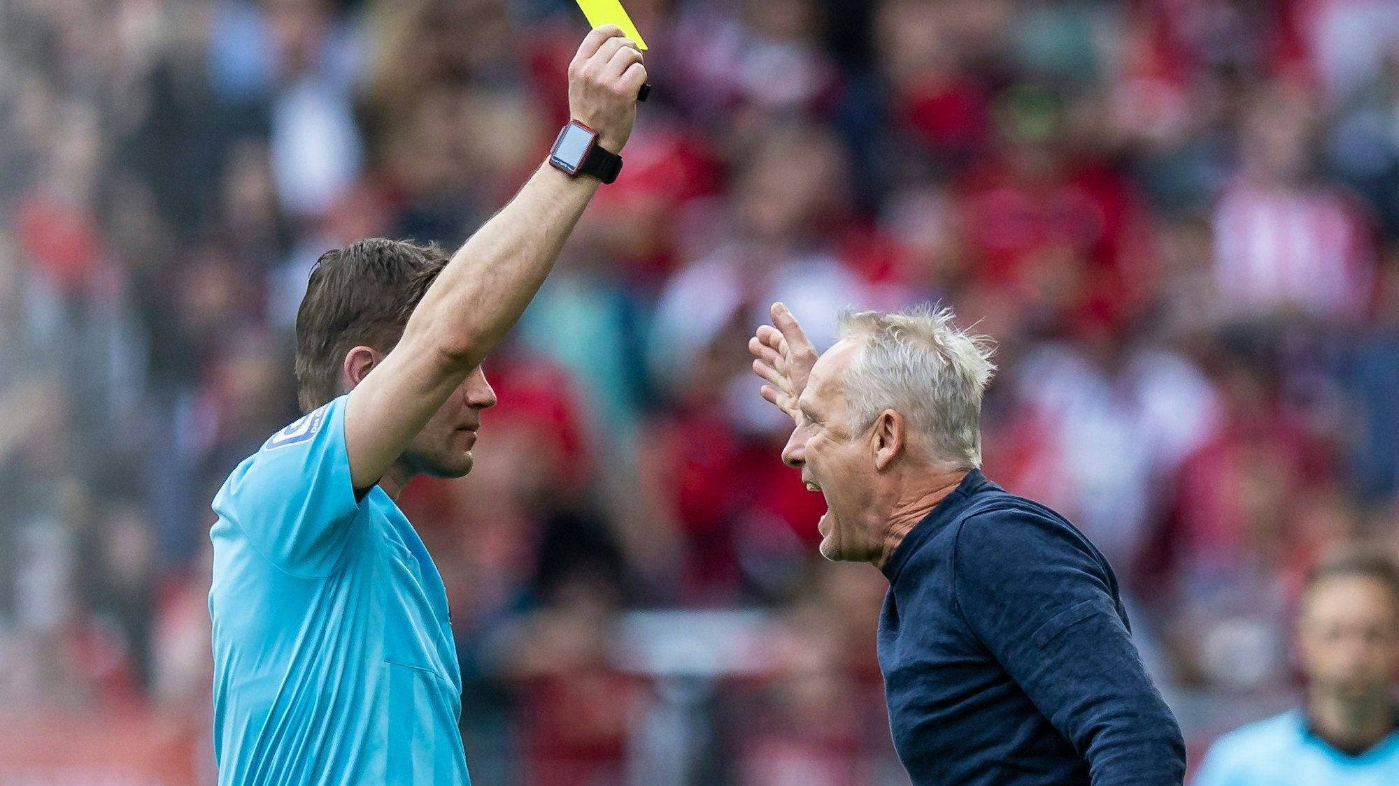 Christian Streich brüllt nach einem Tor für Union Berlin und sieht von Schiri Felix Brych Gelb wegen Meckerns.