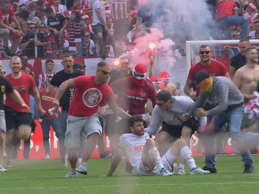 Jonas Hector wird vom Platzsturm der FC-Fans überrollt.