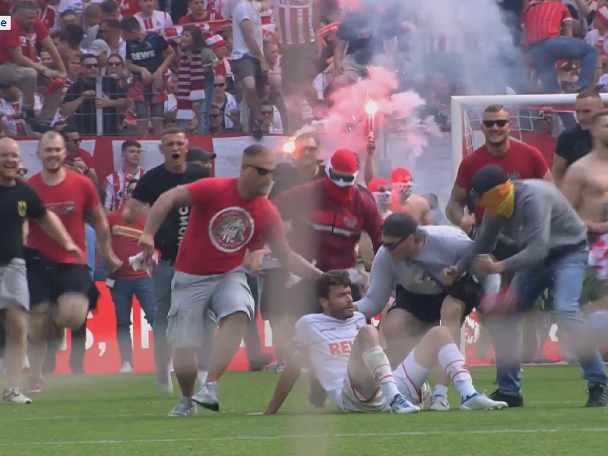 Jonas Hector wird vom Platzsturm der FC-Fans überrollt.