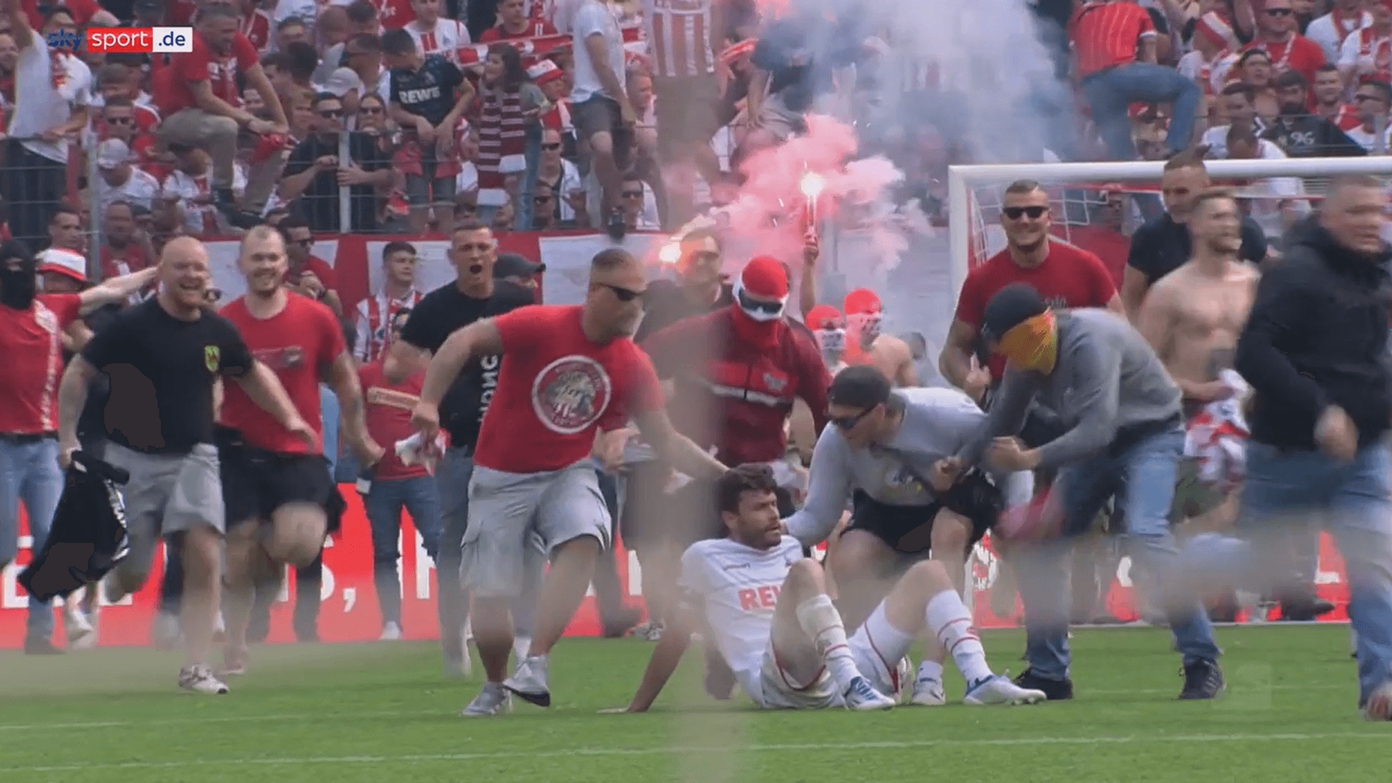 Jonas Hector wird vom Platzsturm der FC-Fans überrollt.