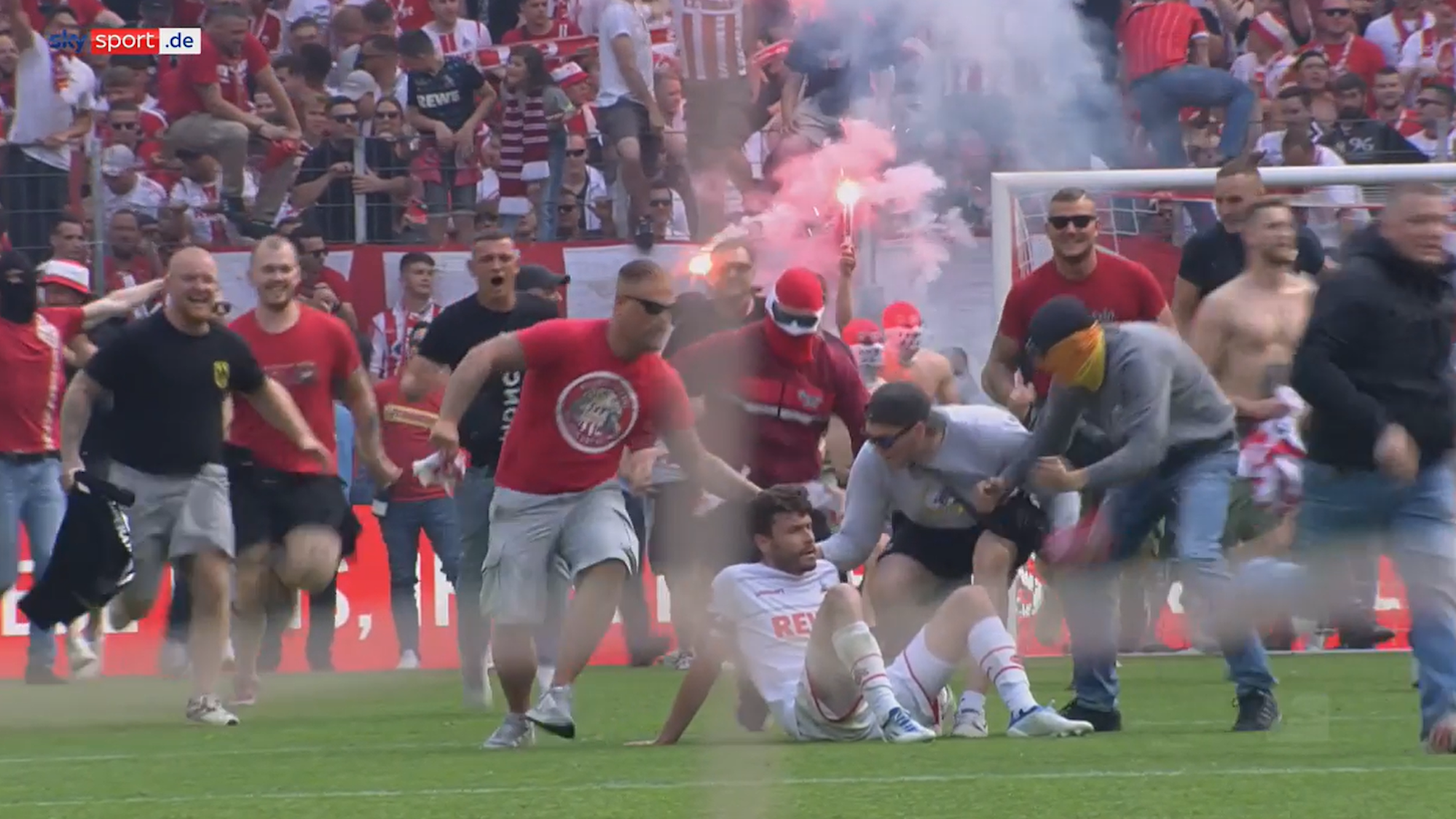 Jonas Hector wird vom Platzsturm der FC-Fans überrollt.