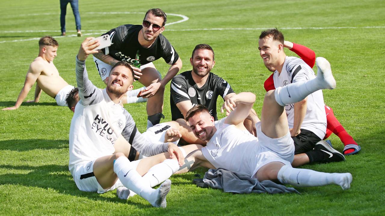Spieler von der SV Elversberg sitzen auf dem Rasen.