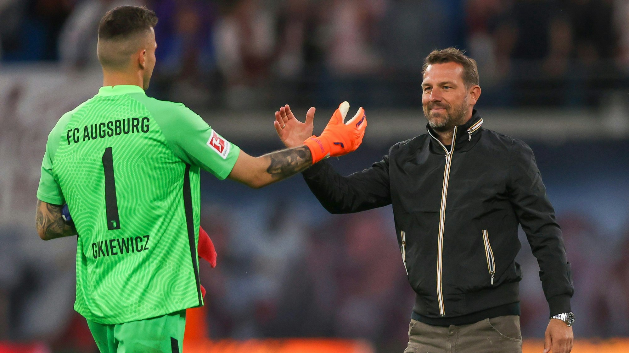Augsburgs Trainer Markus Weinzierl (r) bedankt sich bei Torwart Rafal Gikiewicz.