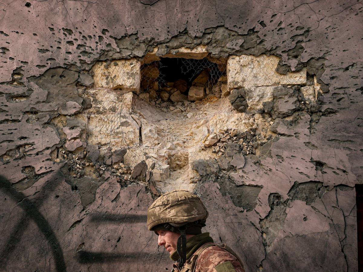 Ein ukrainischer Soldat geht an einem Gebäude vorbei, das von einer großkalibrigen Mörsergranate im Frontdorf Krymske in der Region Luhansk in der Ostukraine getroffen wurde.