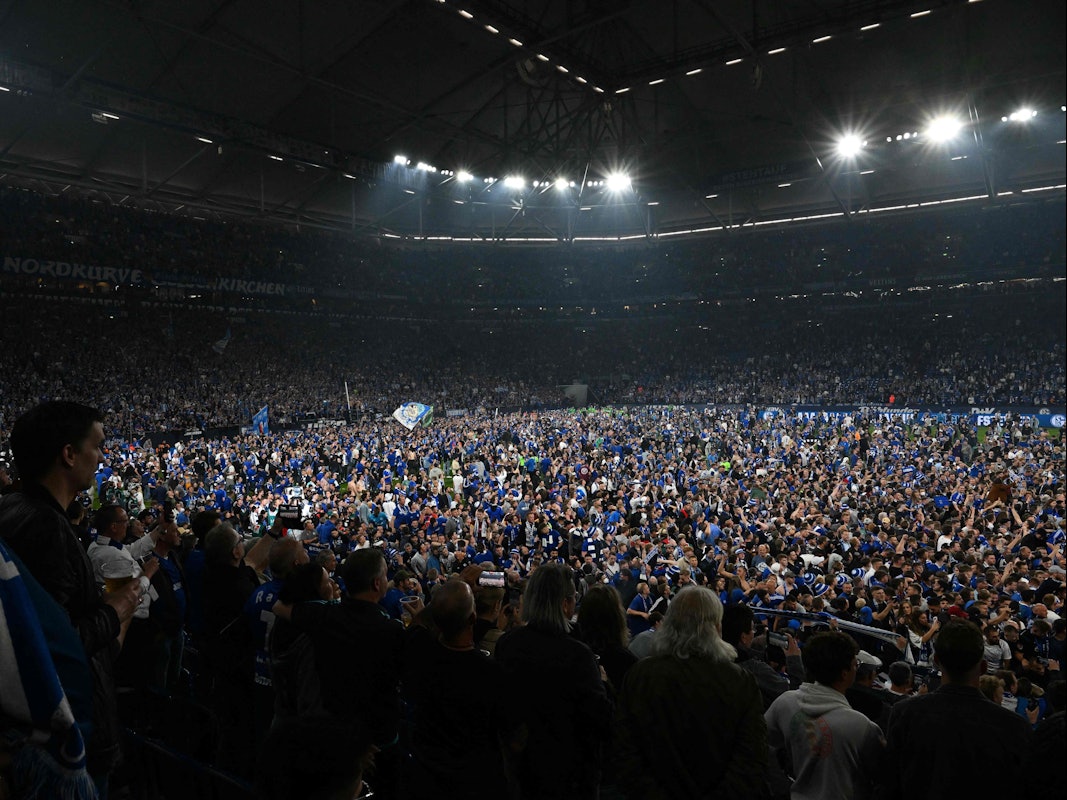 Mehrere Tausend Fans von Schalke 04 stürmen bei den Aufstiegs-Feierlichkeiten den Rasen der Veltins-Arena.