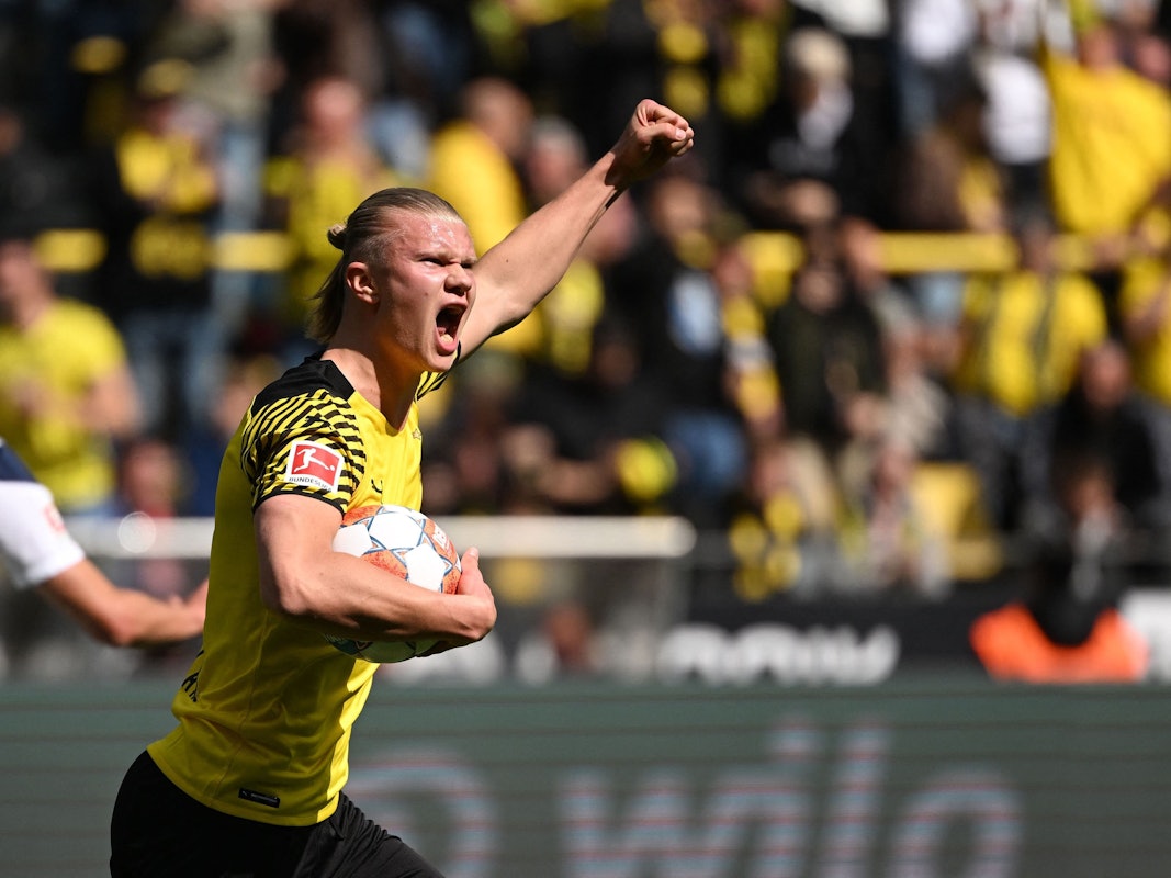 Erling Haaland hat den Ball in der Hand und jubelt mit erhobener Faust.