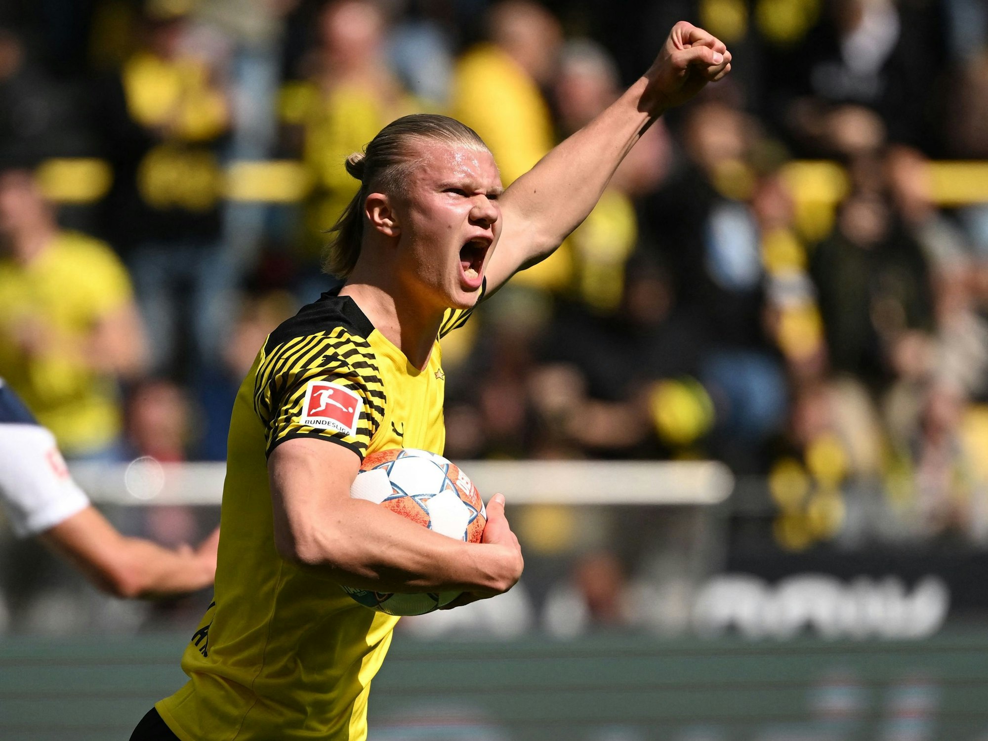 Erling Haaland hat den Ball in der Hand und jubelt mit erhobener Faust.