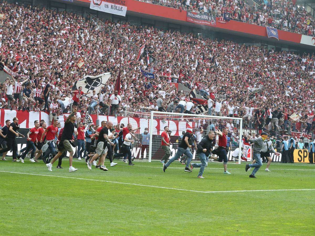 Die Fans des 1. FC Köln stürmen den Platz.
