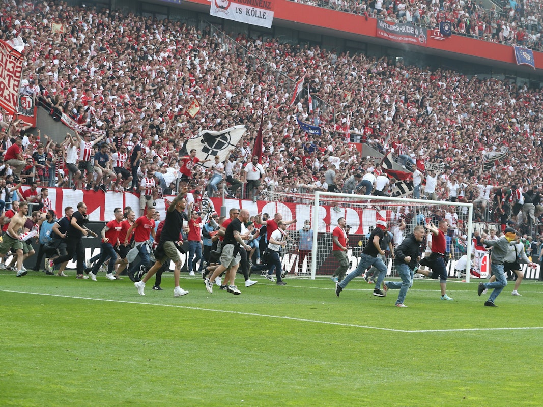 Die Fans des 1. FC Köln stürmen den Platz.