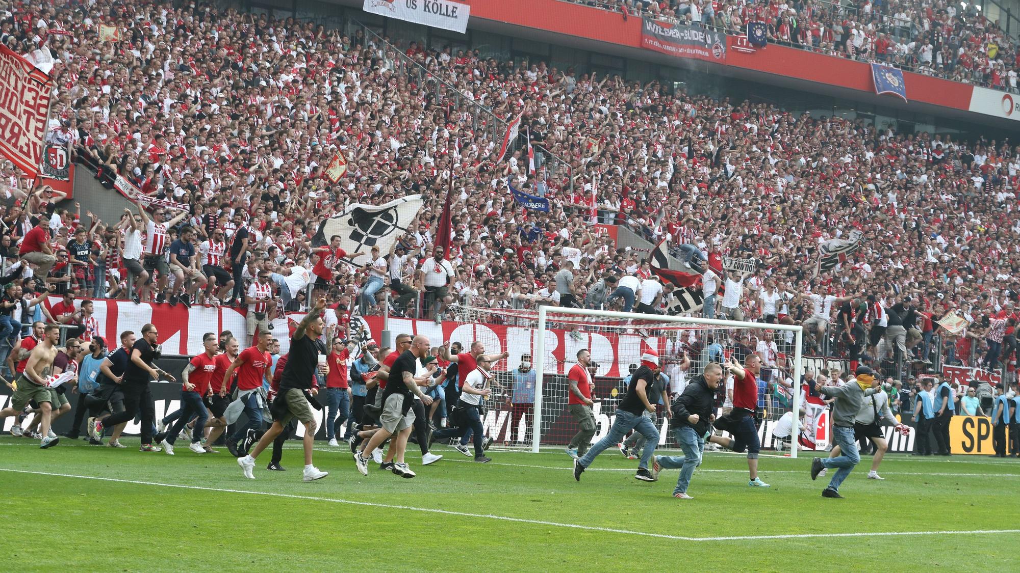 Die Fans des 1. FC Köln stürmen den Platz.