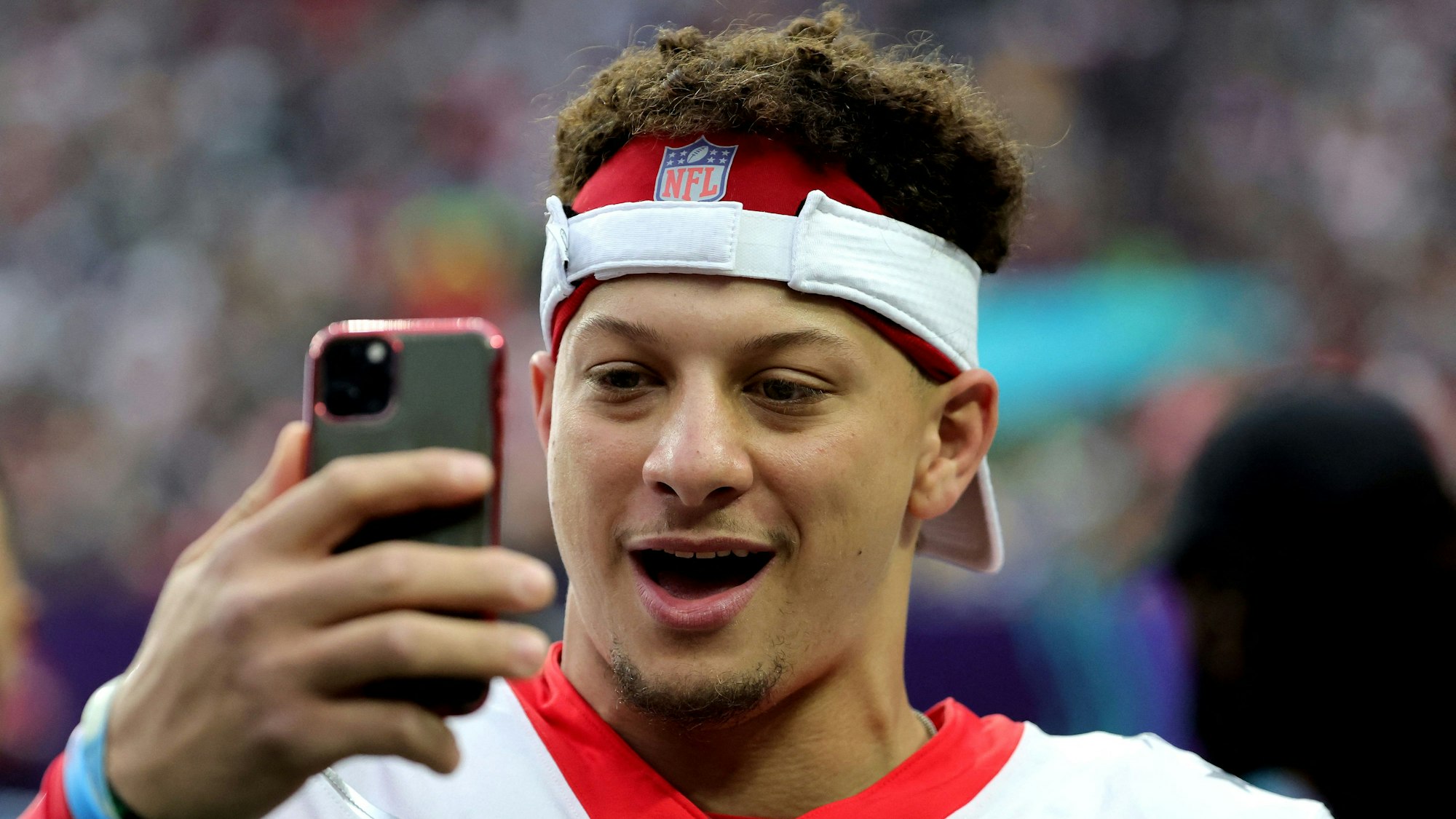 Patrick Mahomes blickt am Rande des Pro Bowl der NFL auf sein Handy.