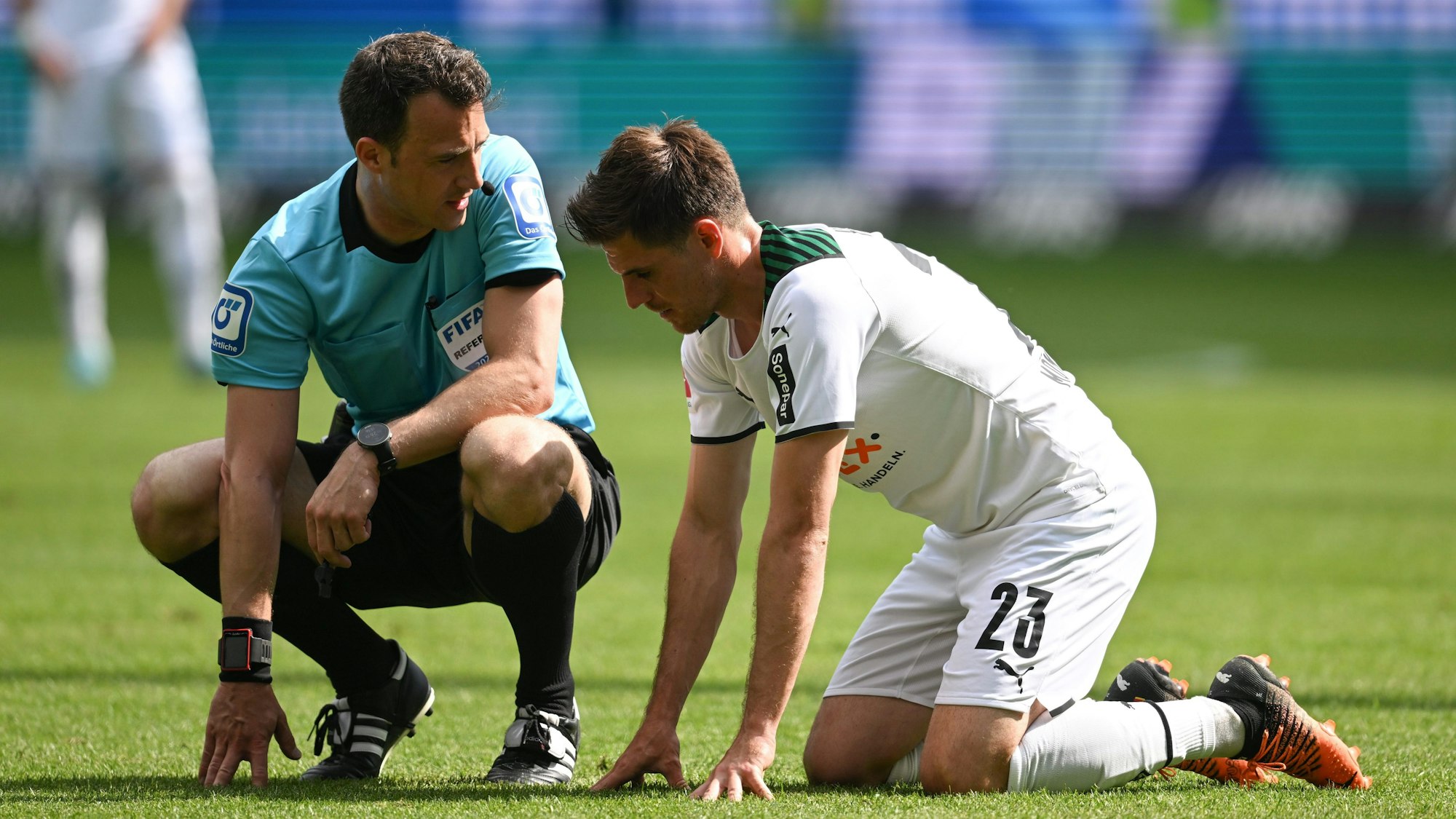 Schiri Felix Zwayer kniet beim Bundesliga-Spiel zwischen Eintracht Frankfurt und Borussia Mönchengladbach neben Gäste-Profi Jonas Hofmann.