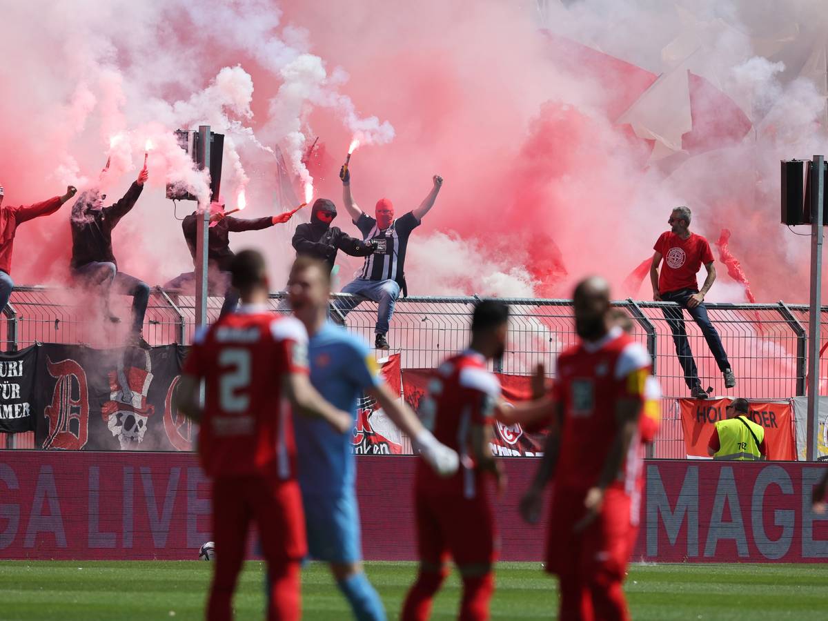 Fans zünden Benaglos im Hintergrund vor einem Fußballspiel.