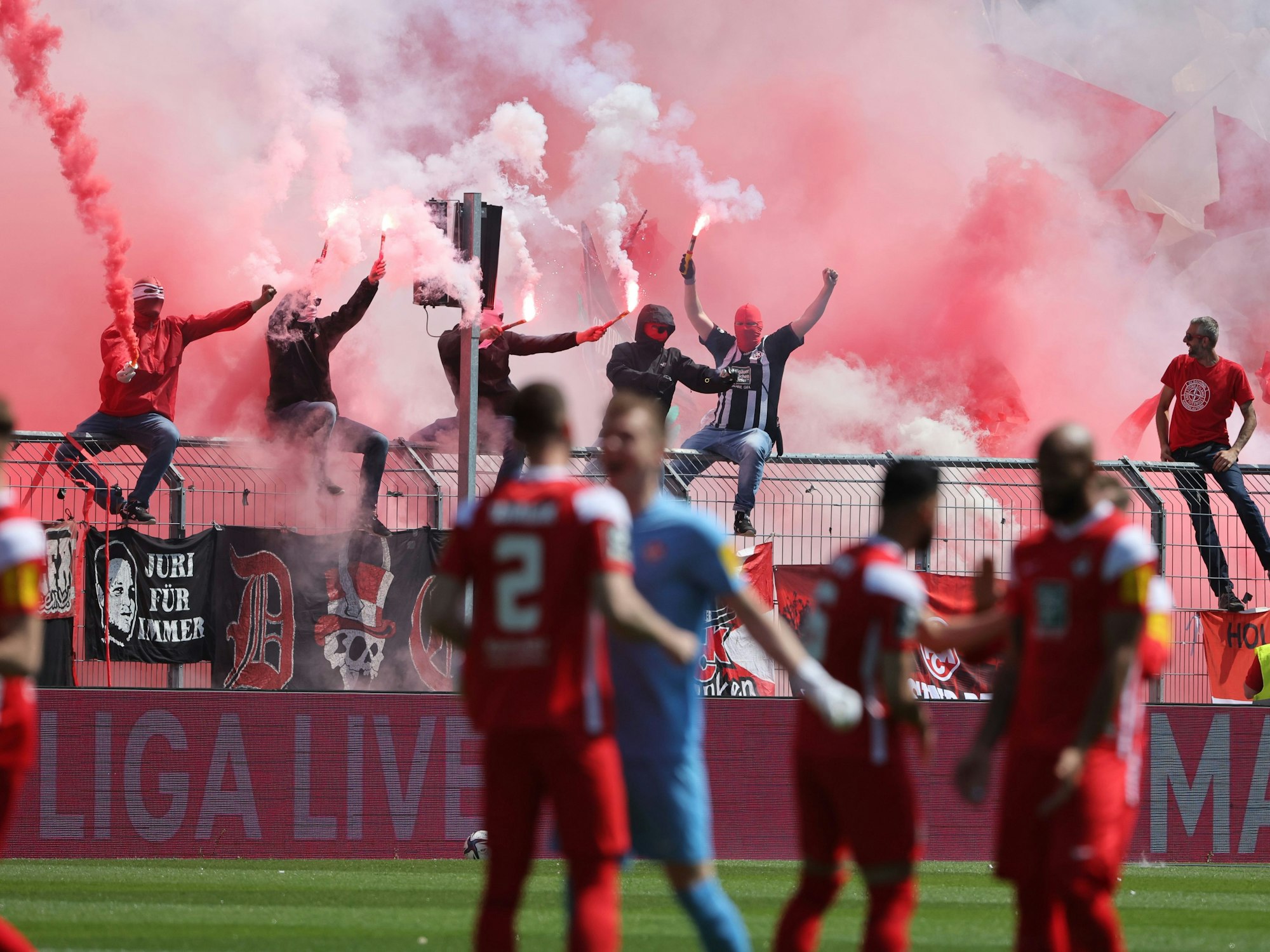 Fans zünden Benaglos im Hintergrund vor einem Fußballspiel.