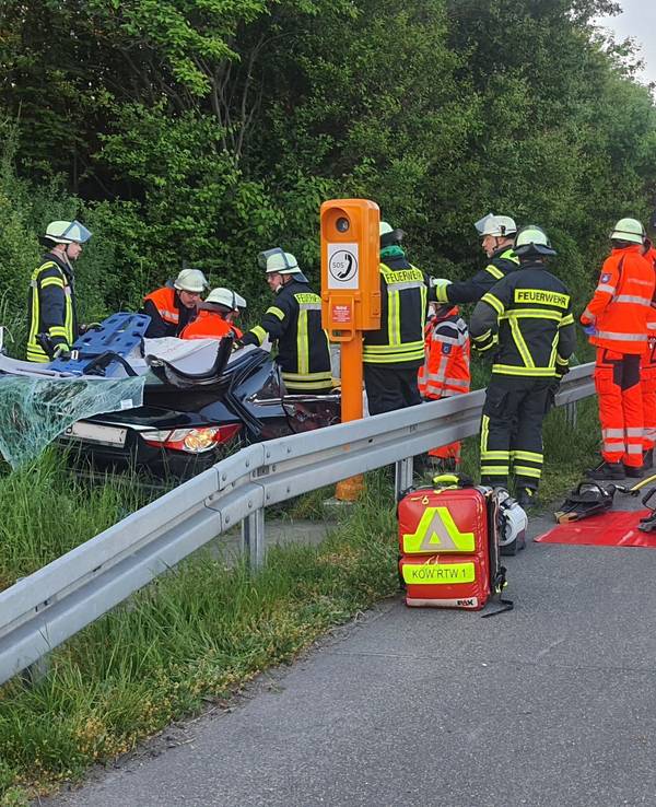 Auto steht nach Unfall neben A3, Feuerwehr mit mehreren Fahrzeugen vor Ort.