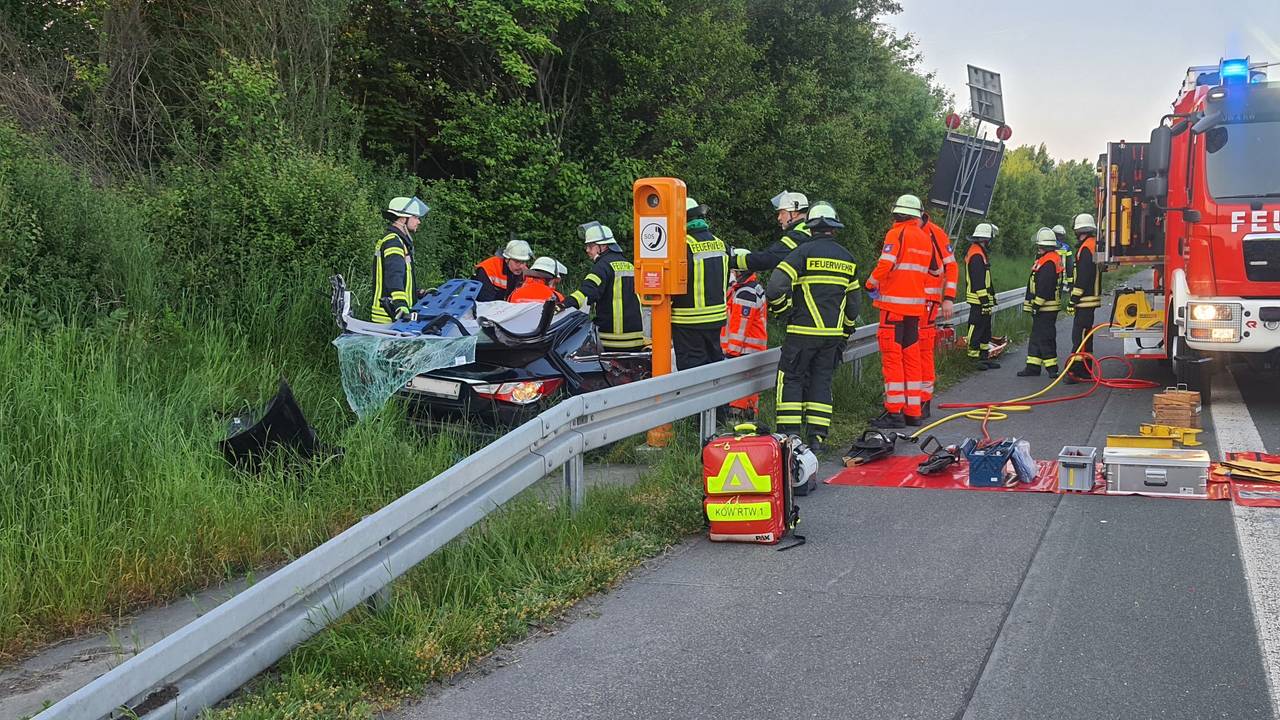 Auto steht nach Unfall neben A3, Feuerwehr mit mehreren Fahrzeugen vor Ort.