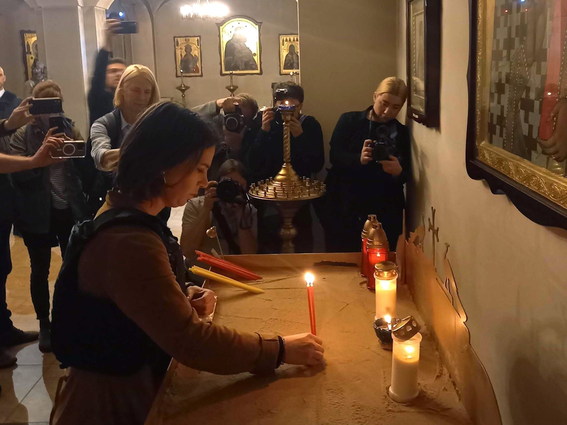 Außenministerin Annalena Baerbock (M, Bündnis 90/Grüne) entzündet am 10. Mai 2022 eine Kerze für die Opfer in einer Kirche in Butscha.