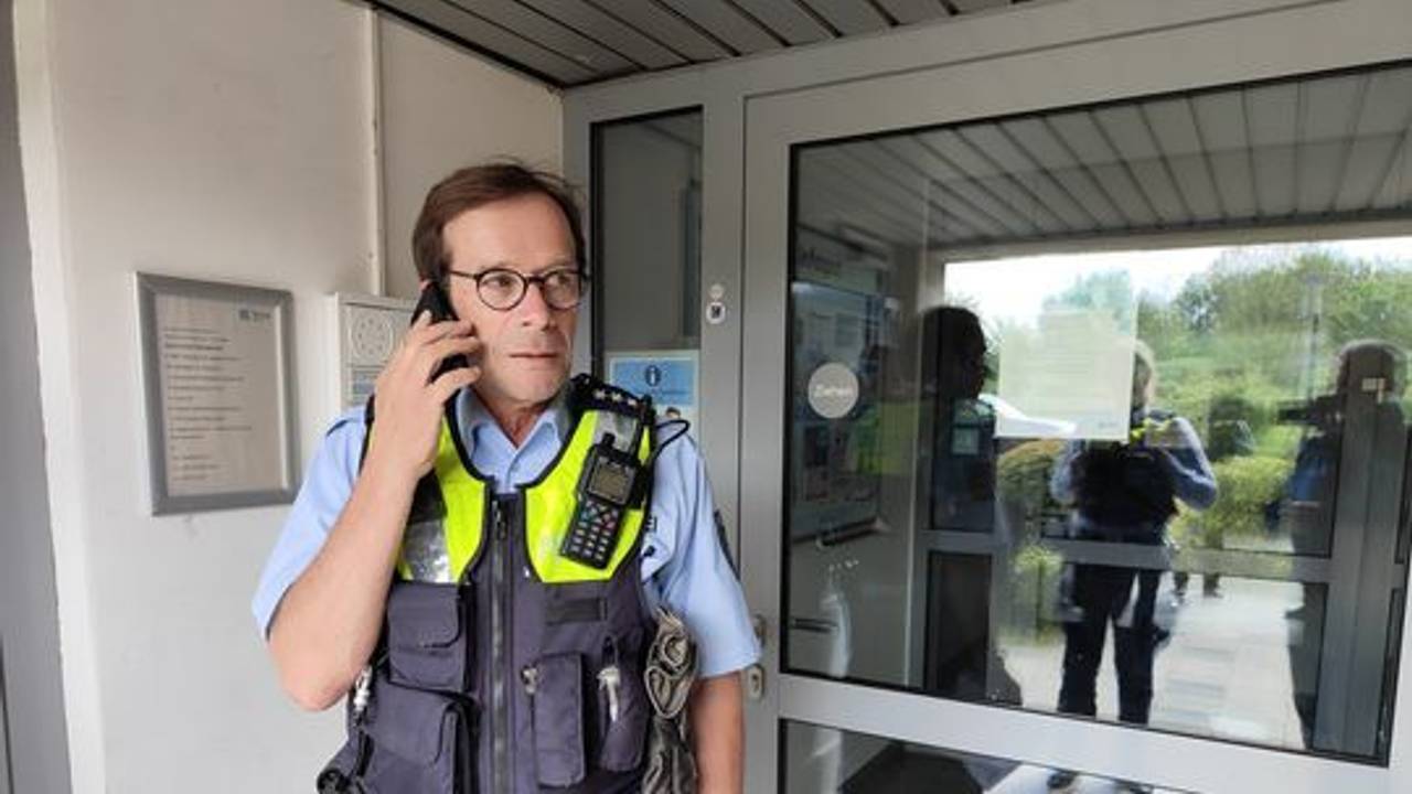 Polizist Sven Bartz telefoniert in einem Hauseingang.