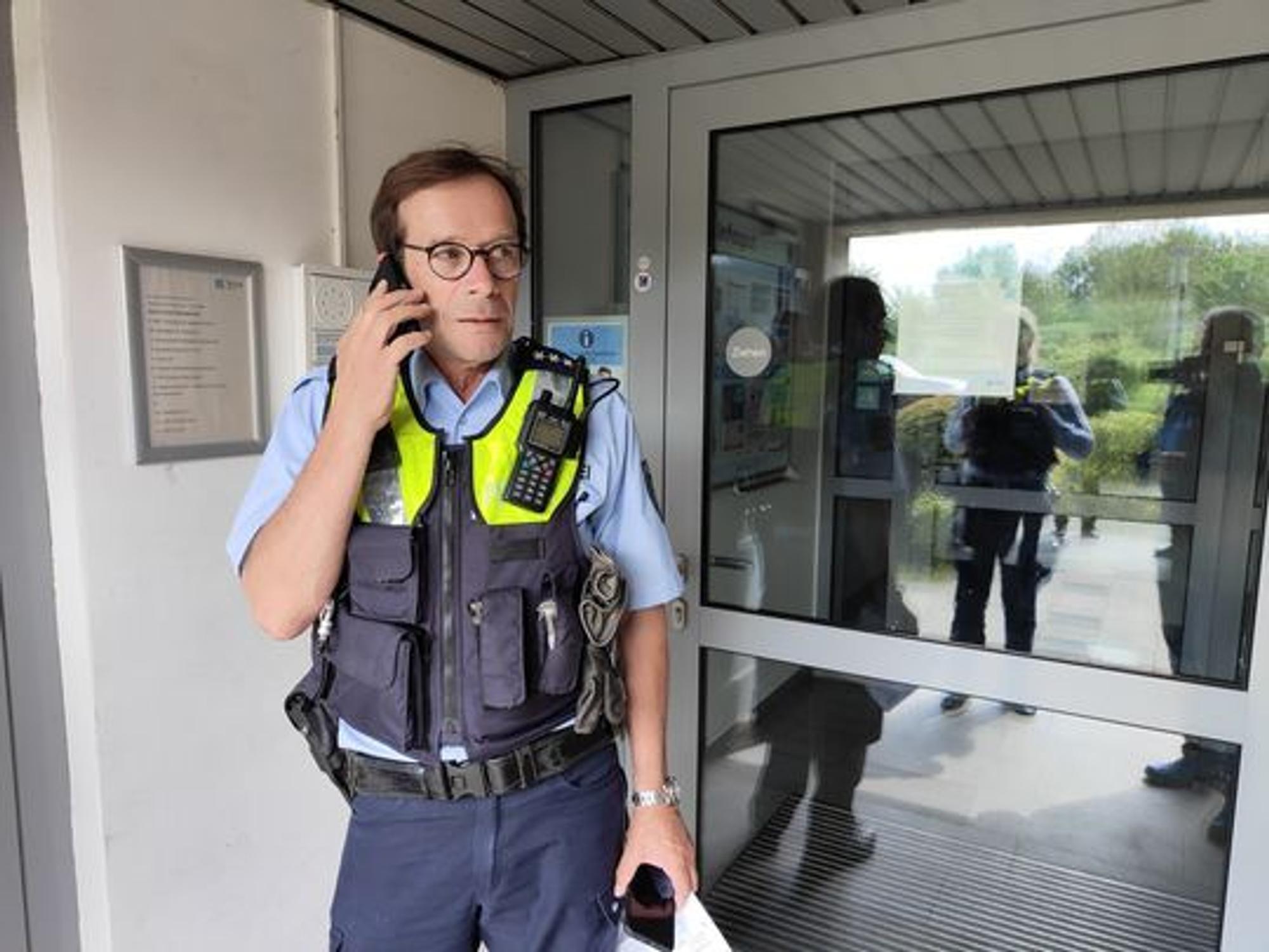 Polizist Sven Bartz telefoniert in einem Hauseingang.