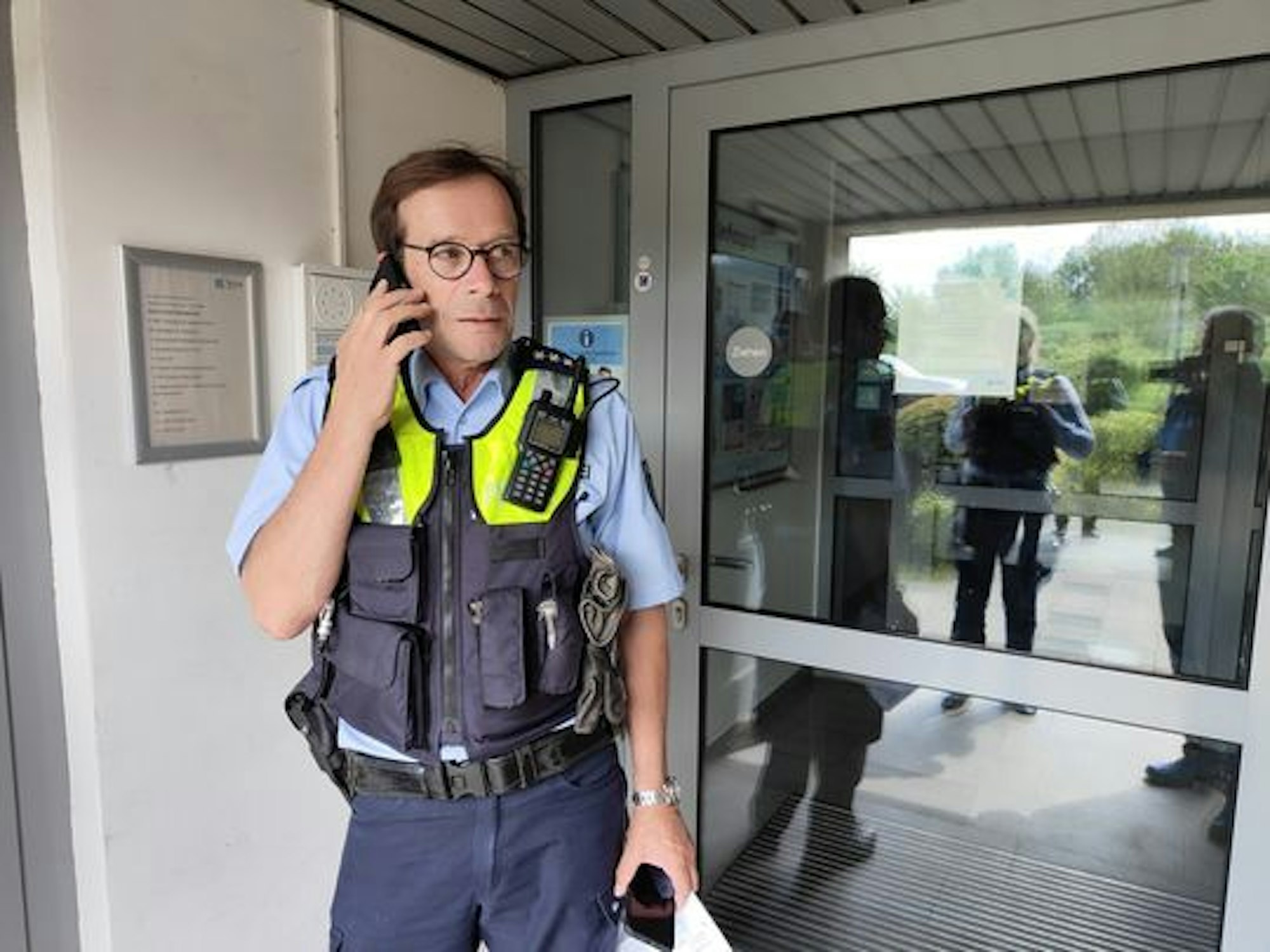 Polizist Sven Bartz telefoniert in einem Hauseingang.