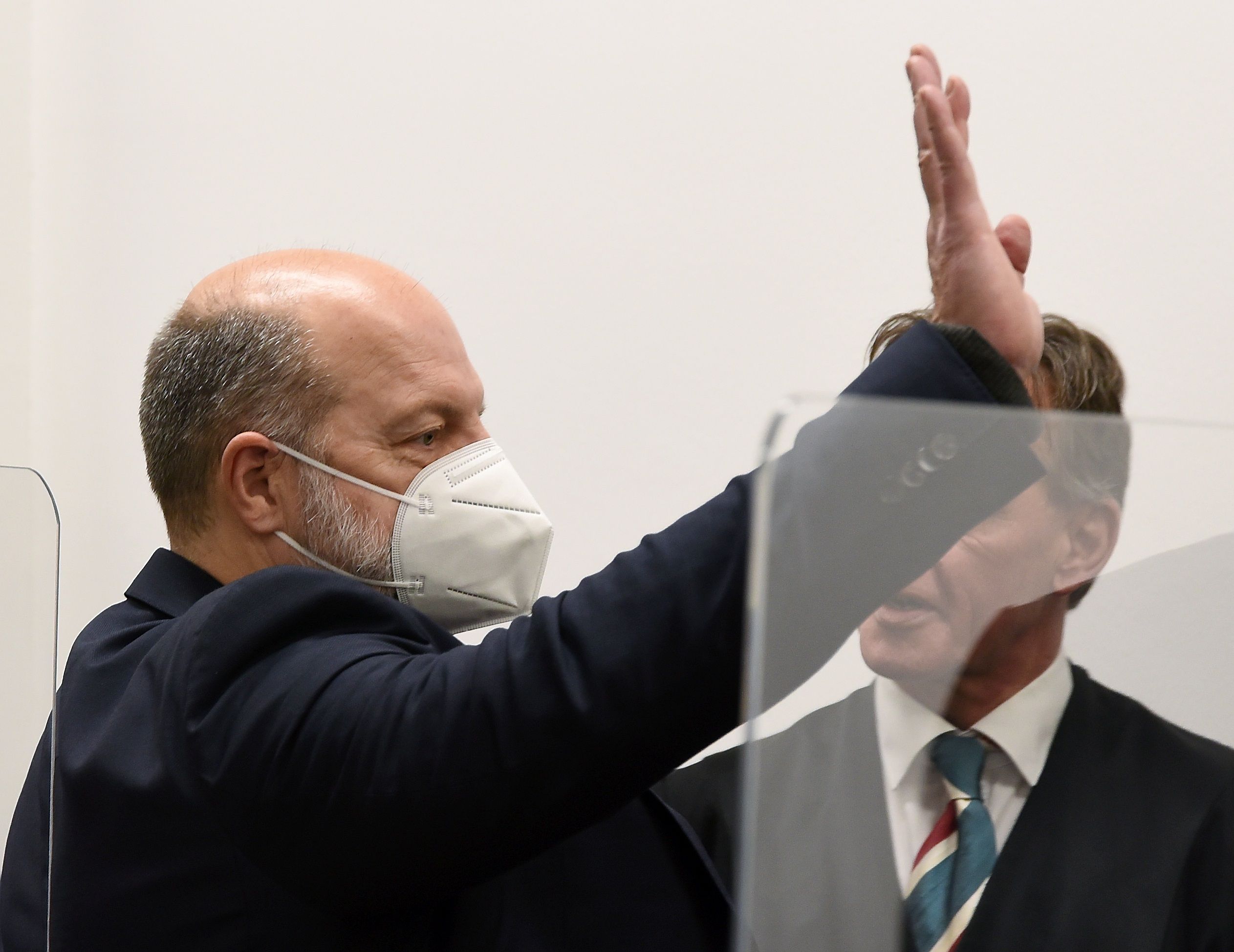 Thomas Drach winkt vor Gericht einer Person zu.
