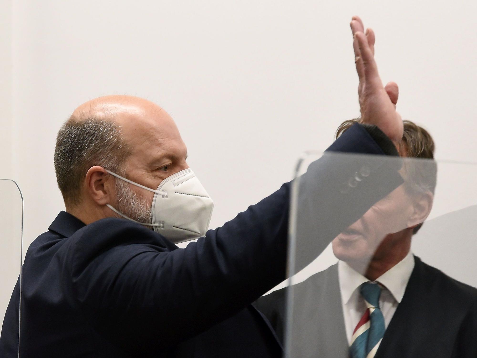 Thomas Drach winkt vor Gericht einer Person zu.