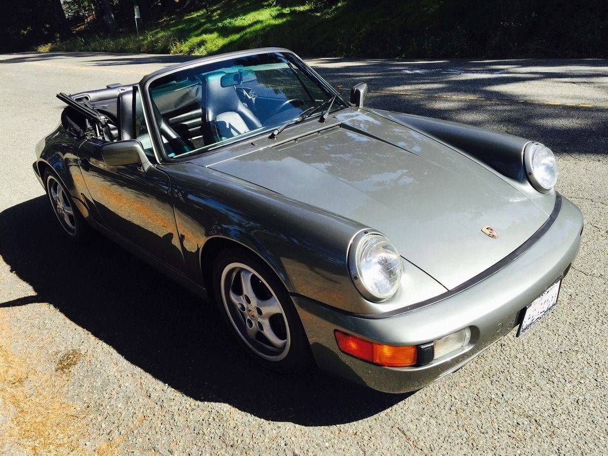 Ein Porsche mit geöffnetem Verdeck steht auf einer Straße.