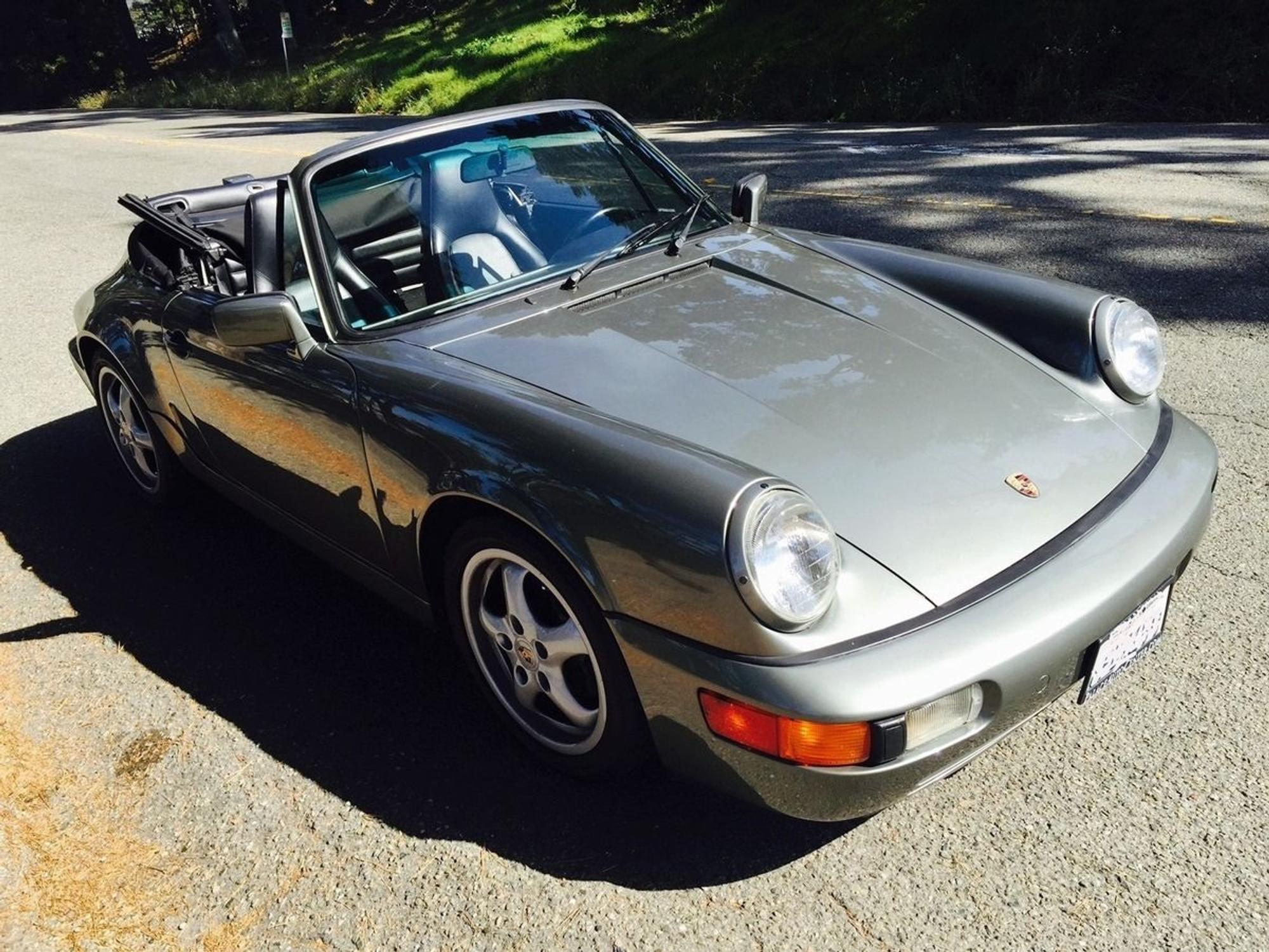 Ein Porsche mit geöffnetem Verdeck steht auf einer Straße.