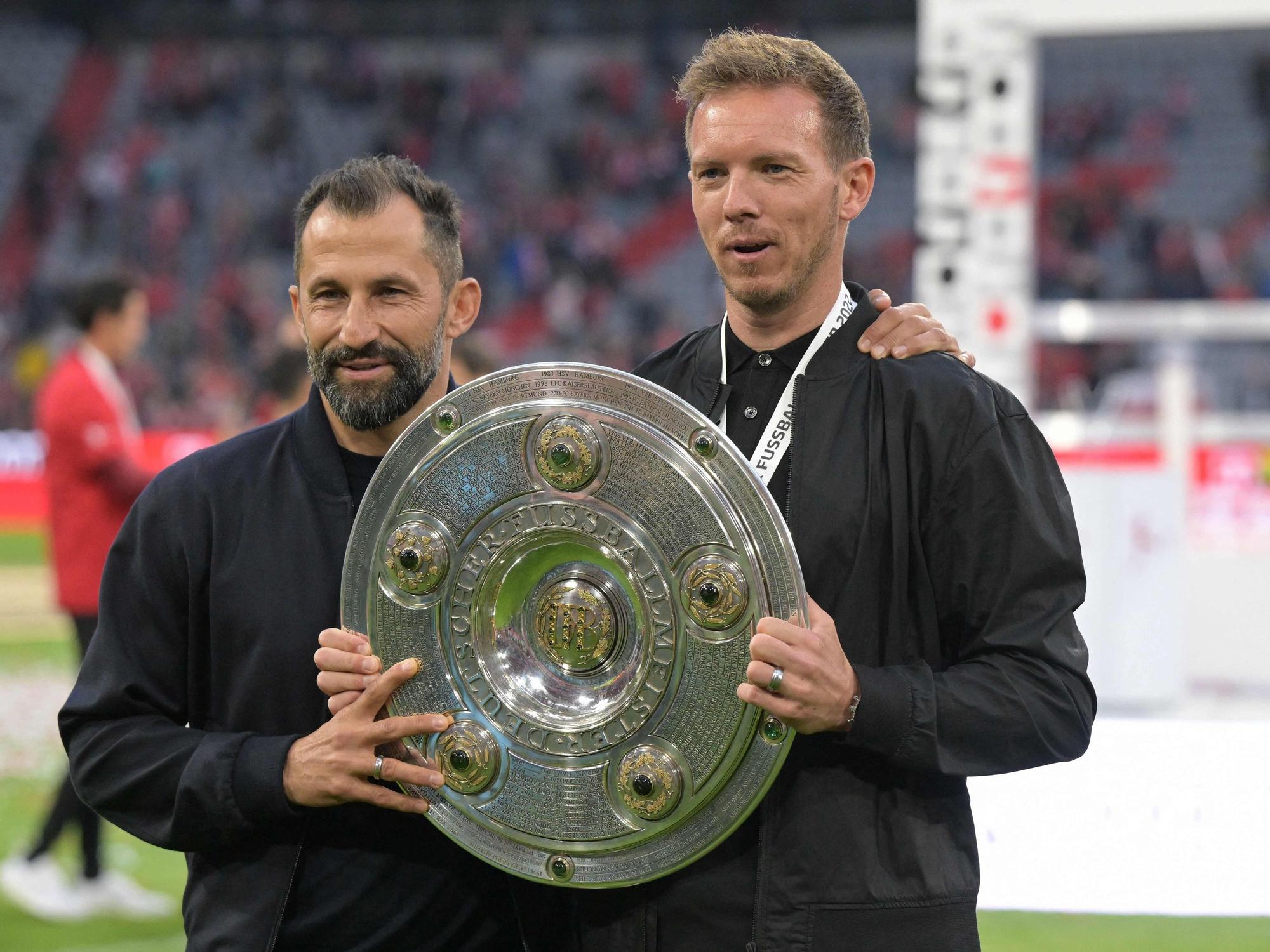Bayern Münchens Trainer Julian Nagelsmann hält mit Sportvorstand Hasan Salihamidzic die Meisterschale.