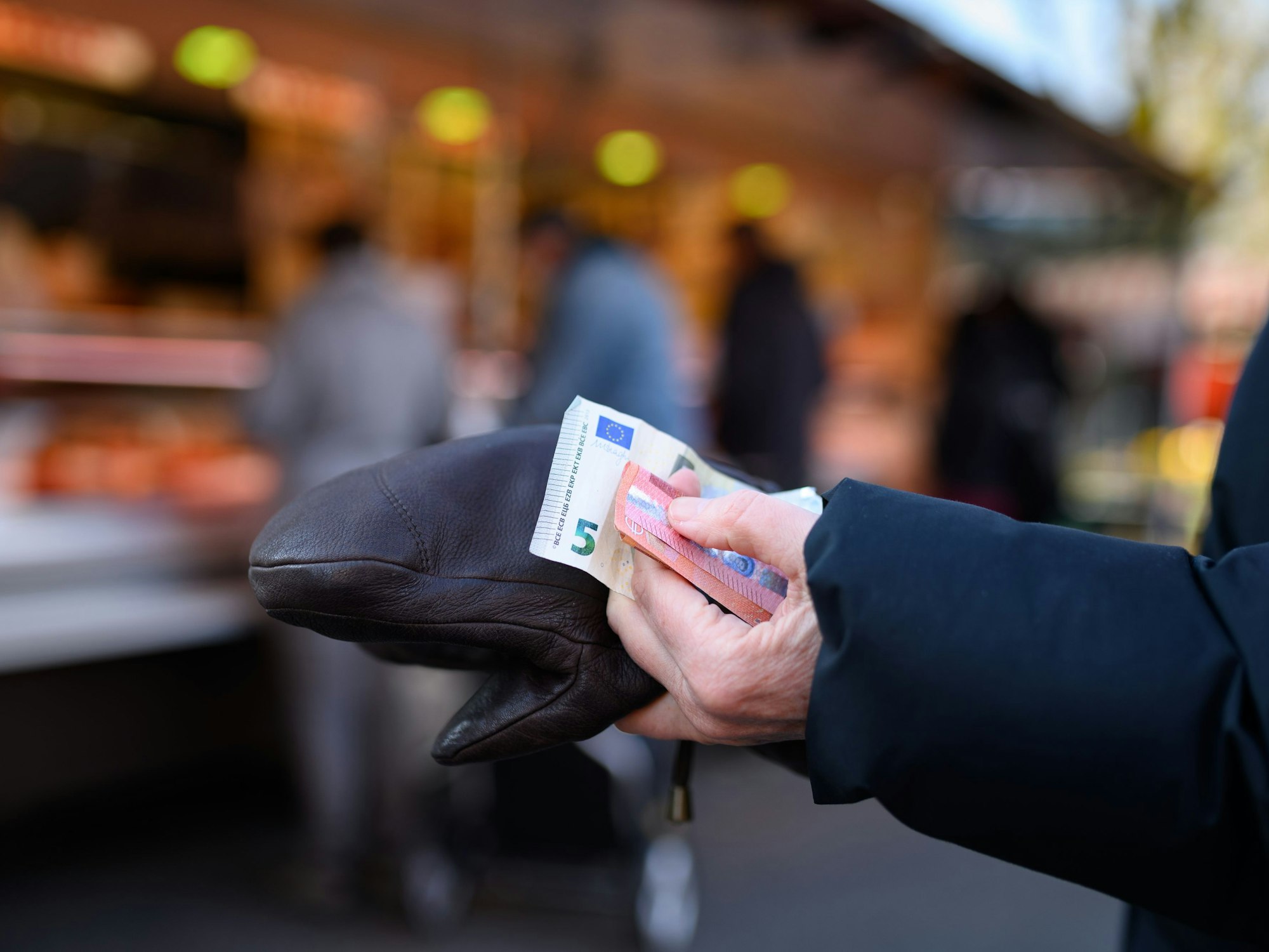 Eine Frau steht am 5. März 2022 an einem Stand an und hält das Bargeld für ihren Einkauf in der Hand bereit.
