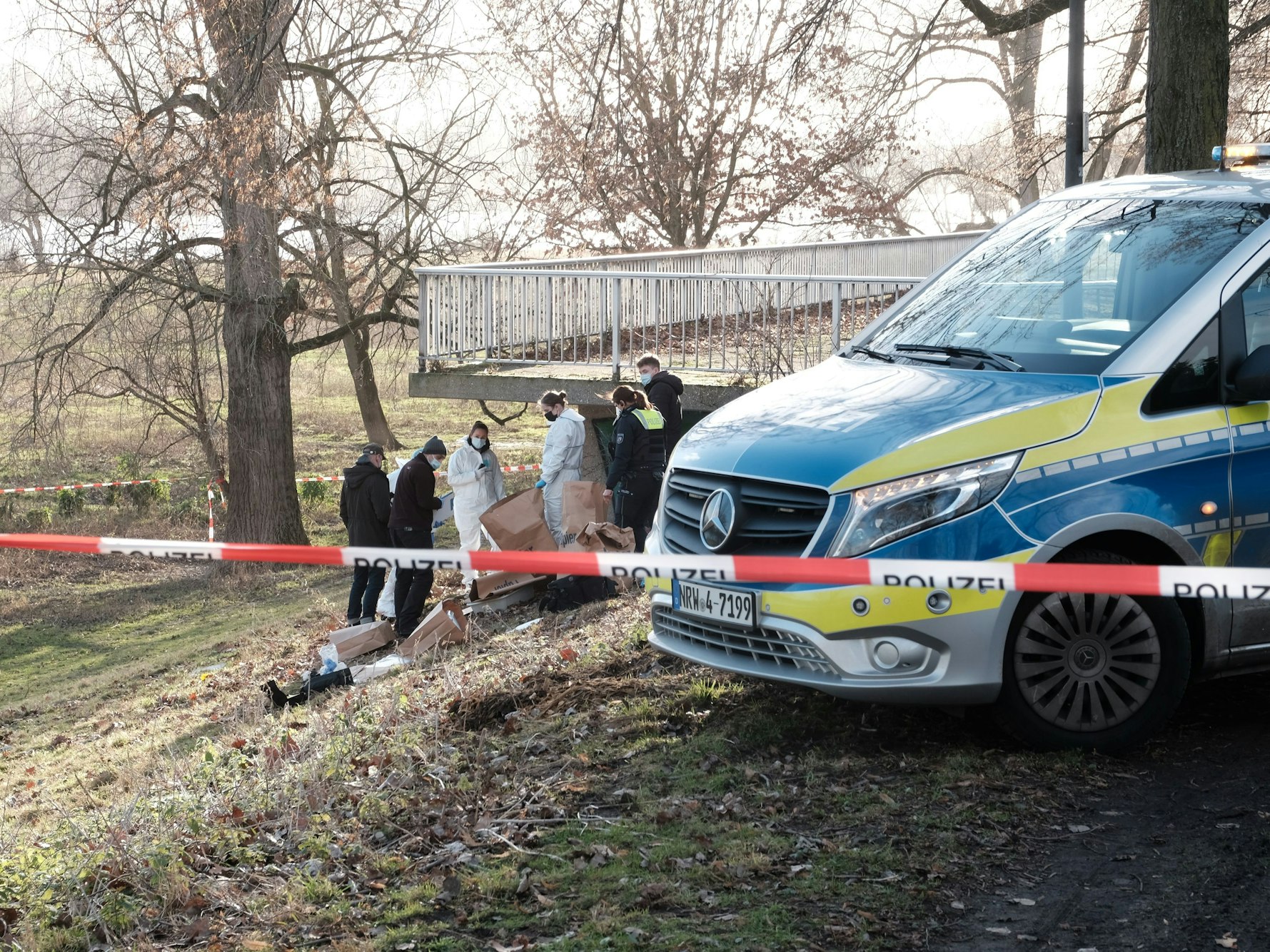 Ermittler der Polizei untersuchen die Fundstelle eines toten Baby am Rheinufer in Köln-Riehl unter eine Aussichtsplattform.