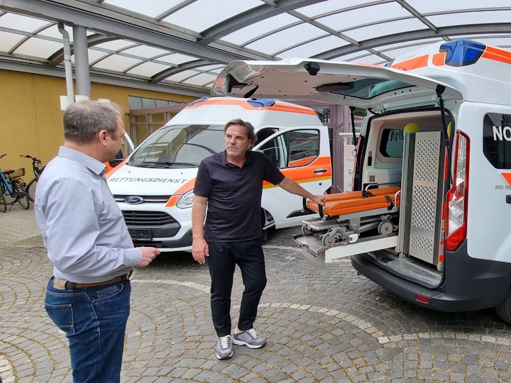 Volker Struth und Christoph Bonsmann mit dem Krankenwagen.