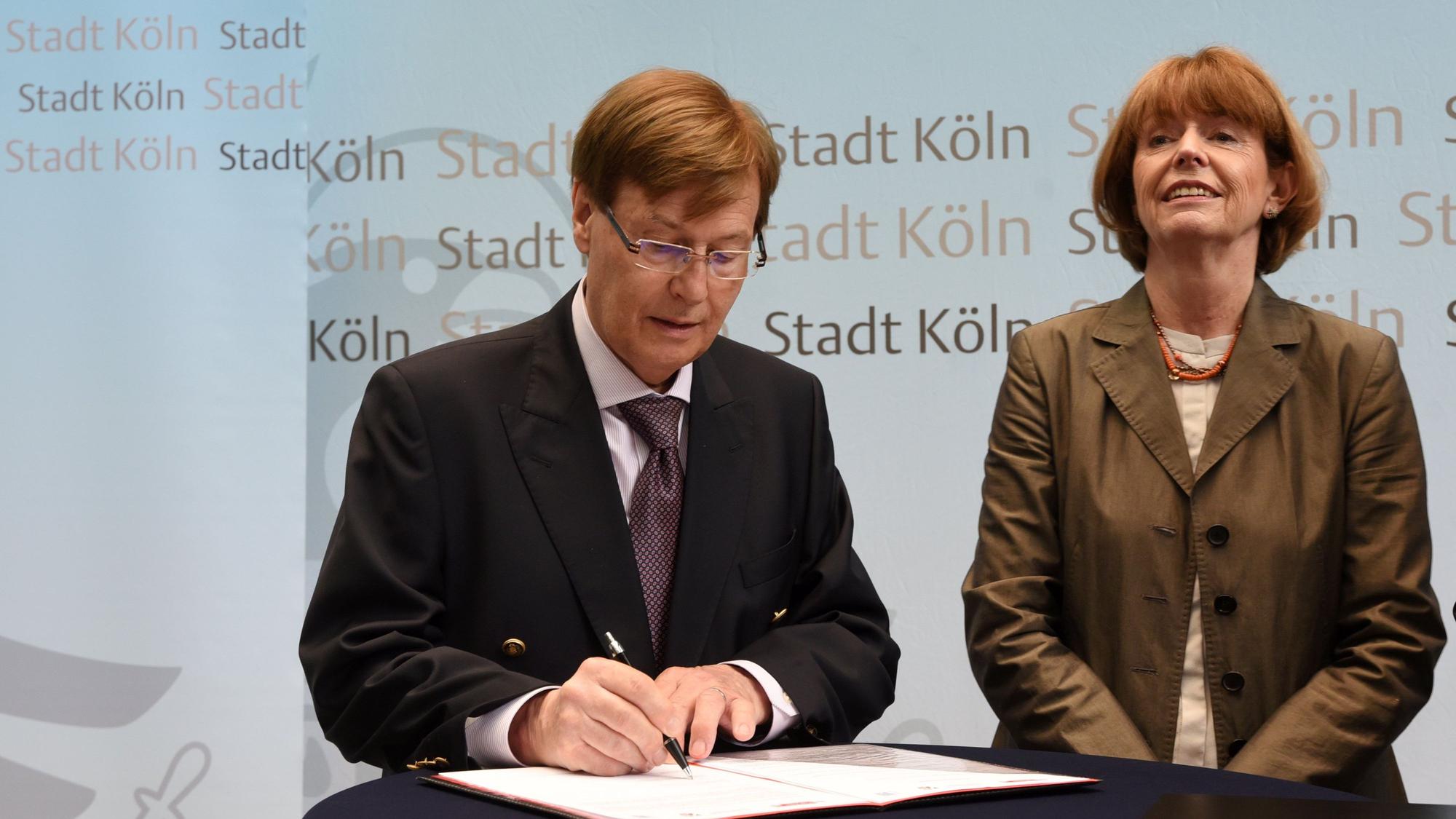 NRW-Justizminister Peter Biesenbach und Kölns OB Henriette Reker unterzeichnen ein Papier.