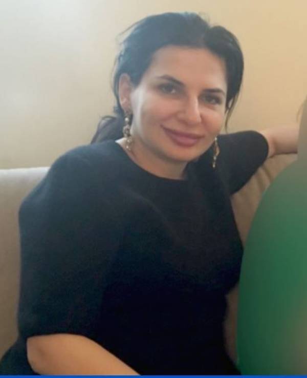 Dr. Ruja Ignatova sitzt auf einem Sessel und lacht in die Kamera.