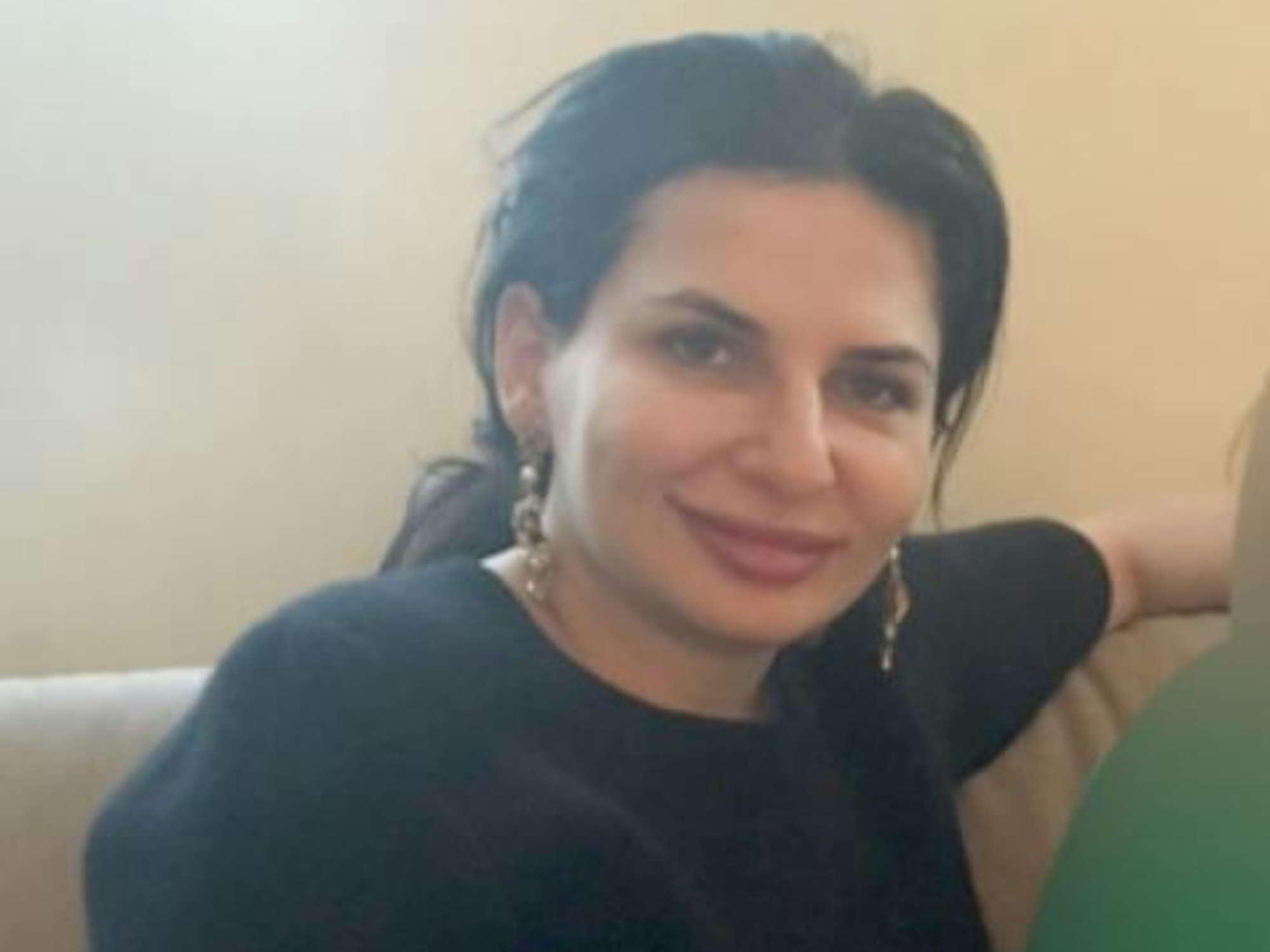 Dr. Ruja Ignatova sitzt auf einem Sessel und lacht in die Kamera.