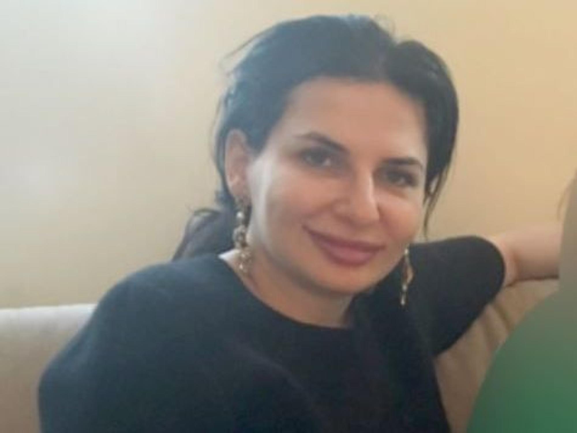 Dr. Ruja Ignatova sitzt auf einem Sessel und lacht in die Kamera.