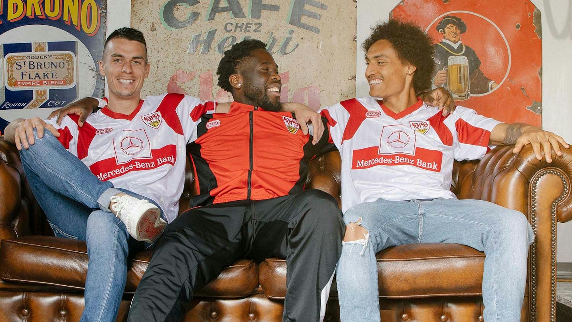 Erik Thommy, Orel Mangala und Enzo Millot sitzen auf einer Couach und stellen die Neuauflage des Meister-Trikots beim VfB Stuttgart vor.