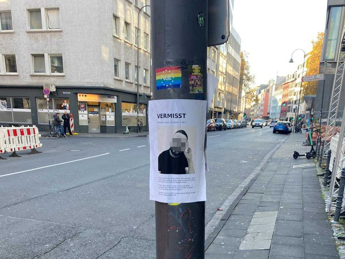 An einem Masten an einer Straße hängt ein Zettel mit dem Foto eines Mannes, darüber steht „Vermisst“.