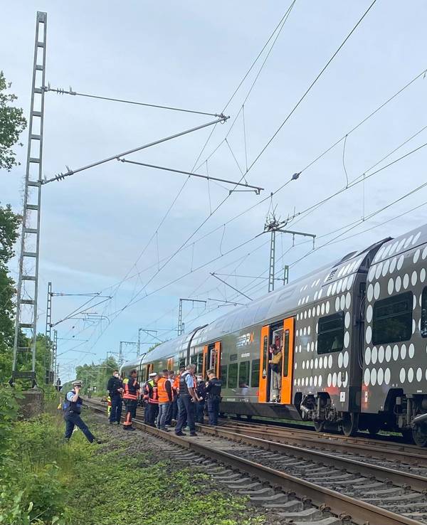 Mehrere Polizeibeamte stehen im Raum Herzogenrath vor einem stehenden Regionalzug.
