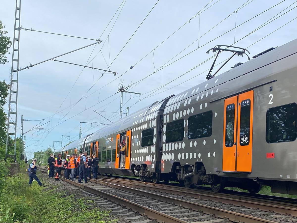 Mehrere Polizeibeamte stehen im Raum Herzogenrath vor einem stehenden Regionalzug.