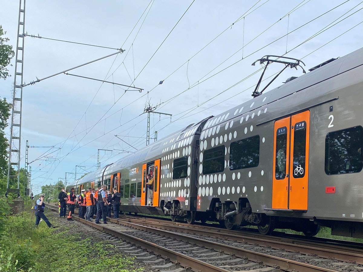 Mehrere Polizeibeamte stehen im Raum Herzogenrath vor einem stehenden Regionalzug.