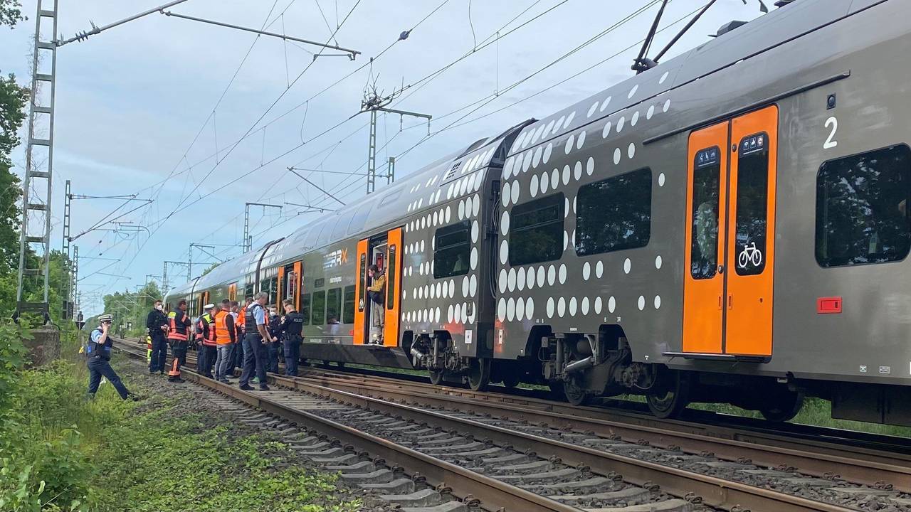 Mehrere Polizeibeamte stehen im Raum Herzogenrath vor einem stehenden Regionalzug.
