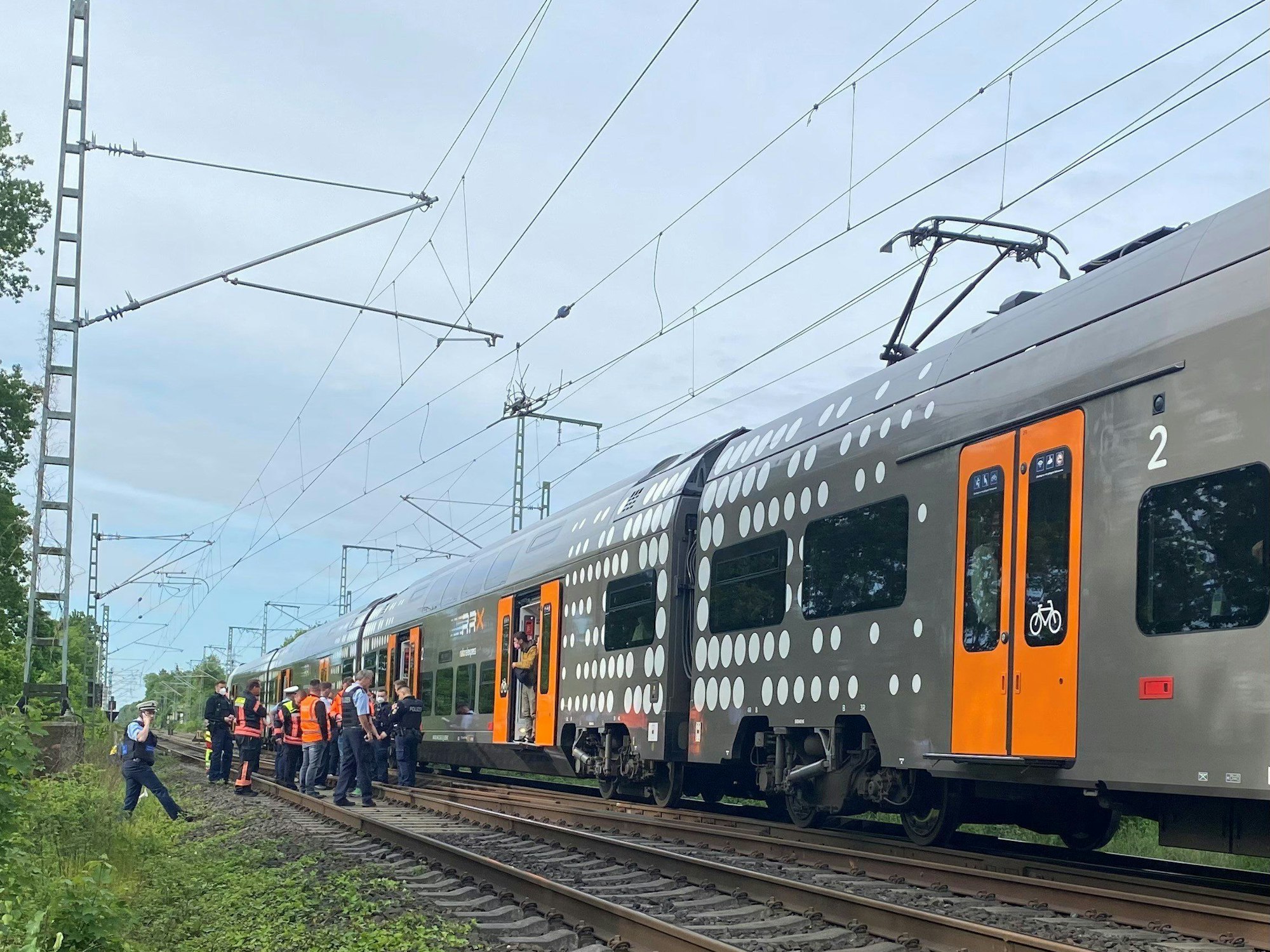 Mehrere Polizeibeamte stehen im Raum Herzogenrath vor einem stehenden Regionalzug.