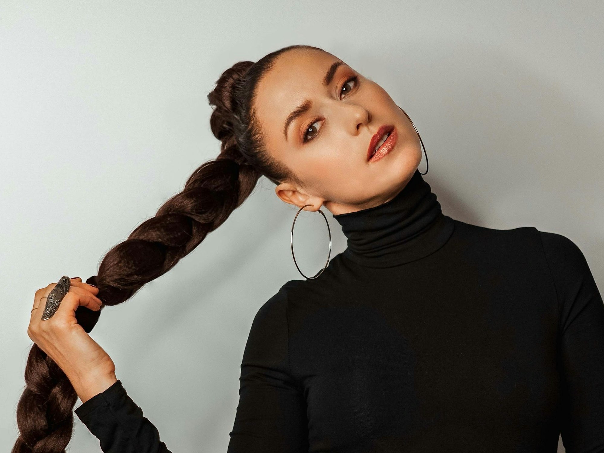 Die schwarz gekleidete Kölner Sängerin Lenny Pojarov schaut mit zur Seite geneigtem Kopf in die Kamera.