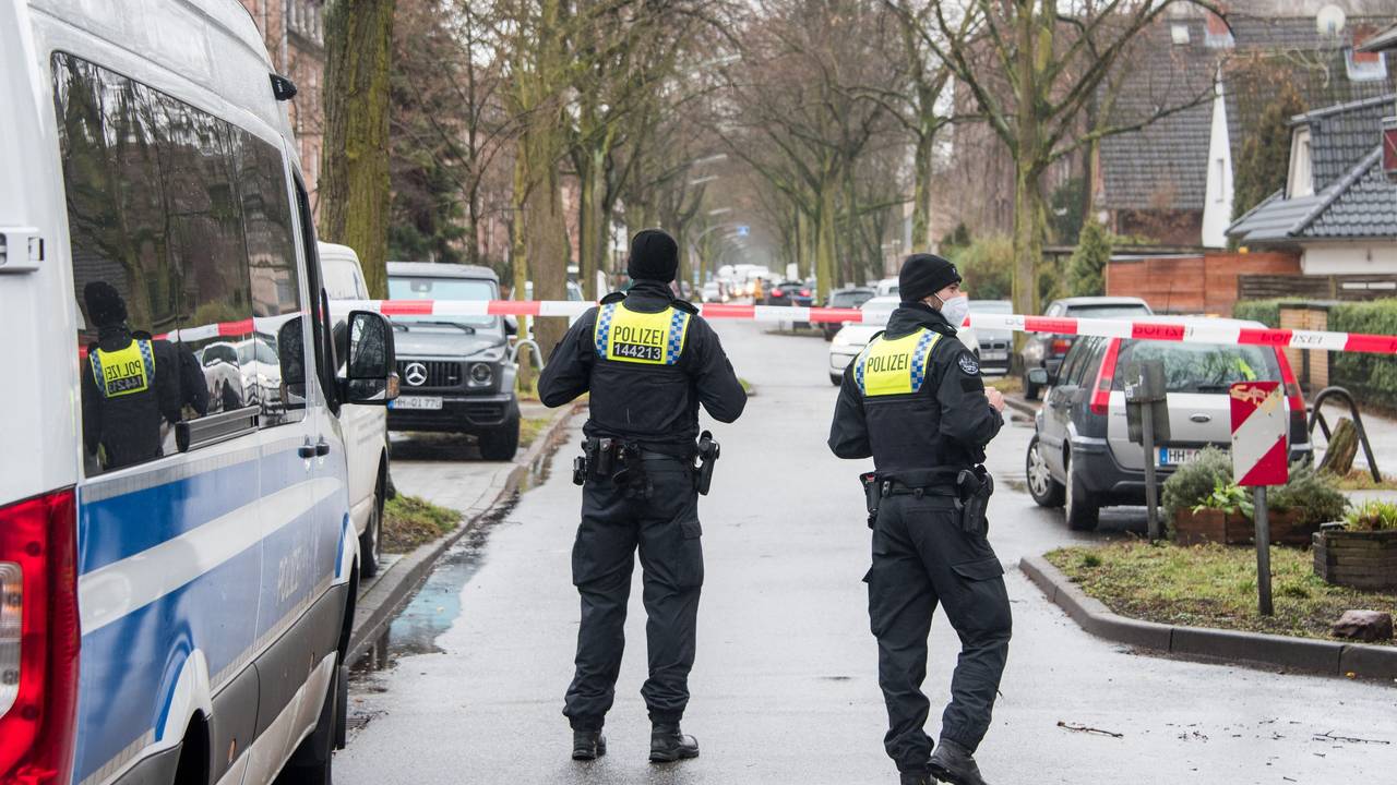 Polizisten sperren eine Straße in einem Wohngebiet.