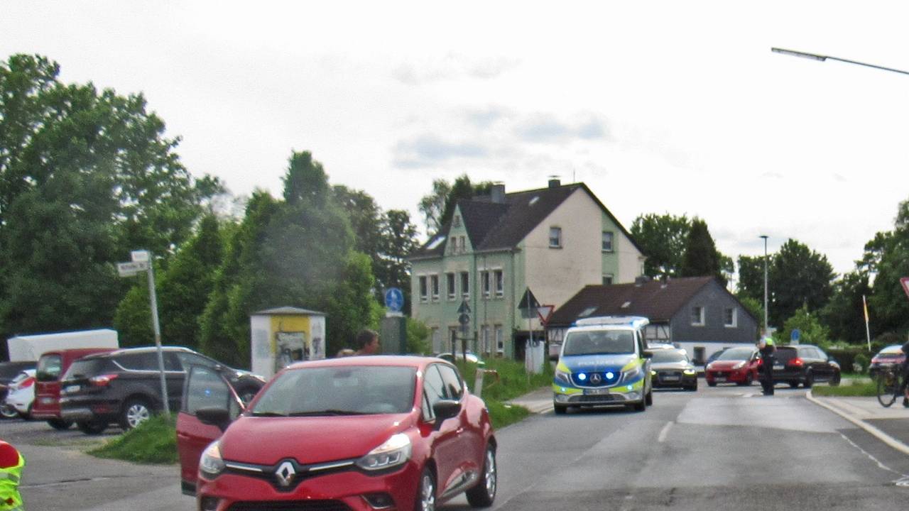 Ein roter Renault Clio steht nach einem Unfall auf der Straße – dahinter ein Polizeifahrzeug.