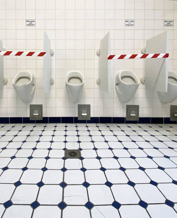 Absperrband ist auf einer Herren-Toilette angebracht.