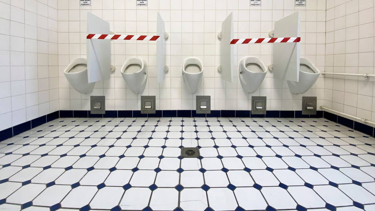 Absperrband ist auf einer Herren-Toilette angebracht.